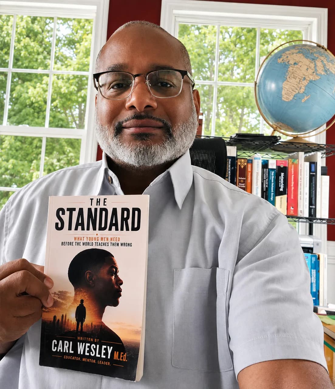 Educator holding The Standard by Carl Wesley