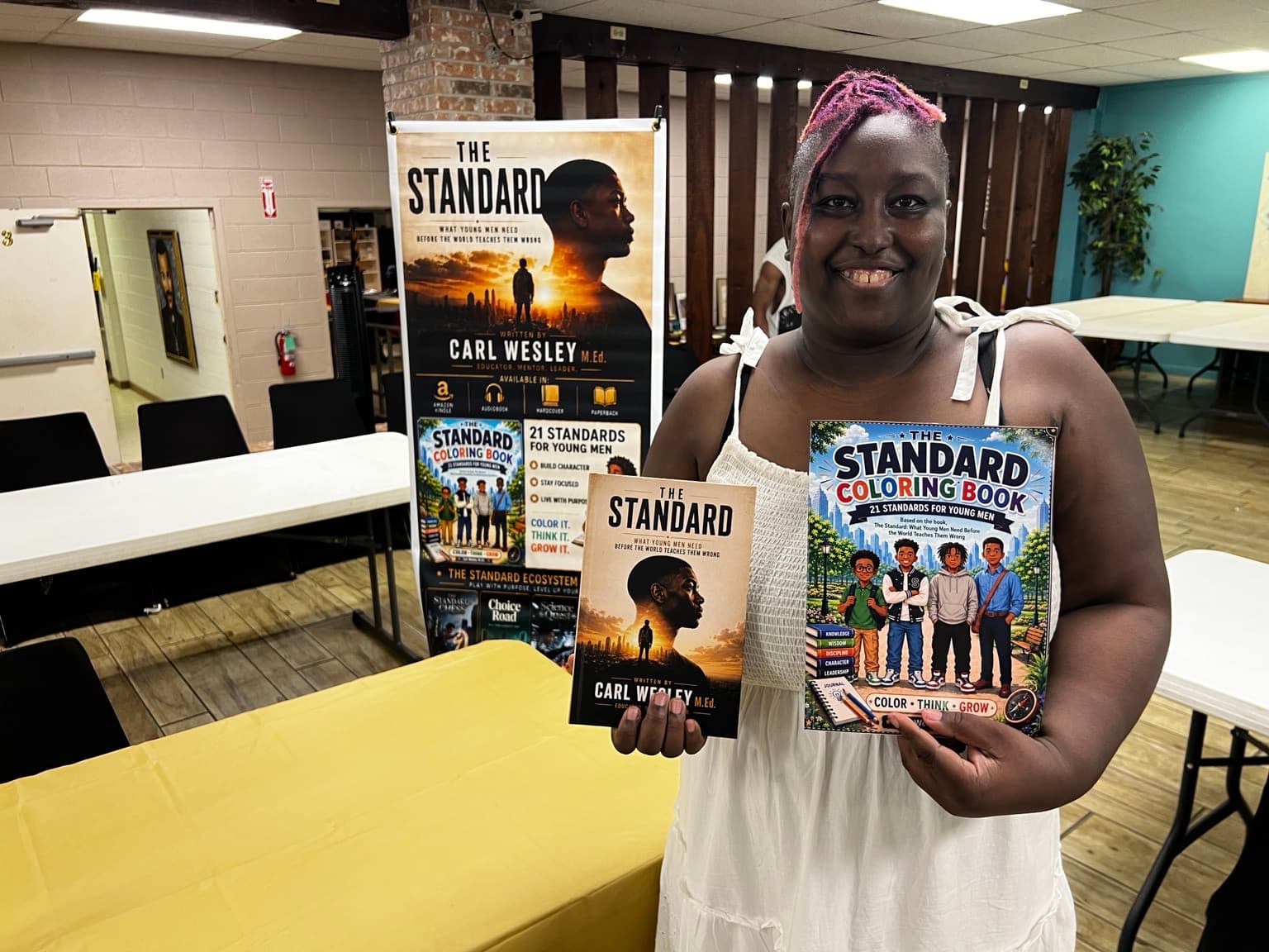 A reader holding The Standard and its coloring book